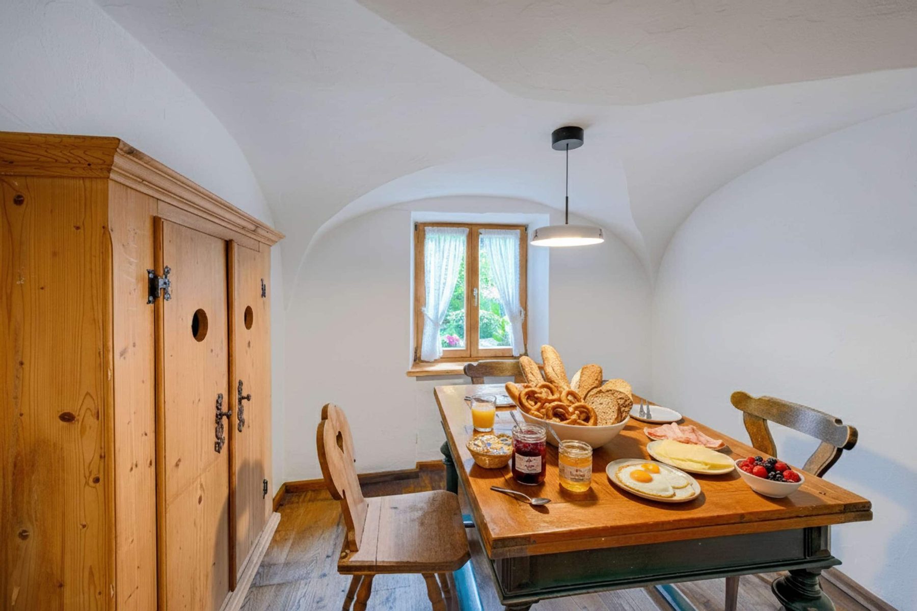 Breakfast nook under the vaulted ceiling, table set for breakfast
