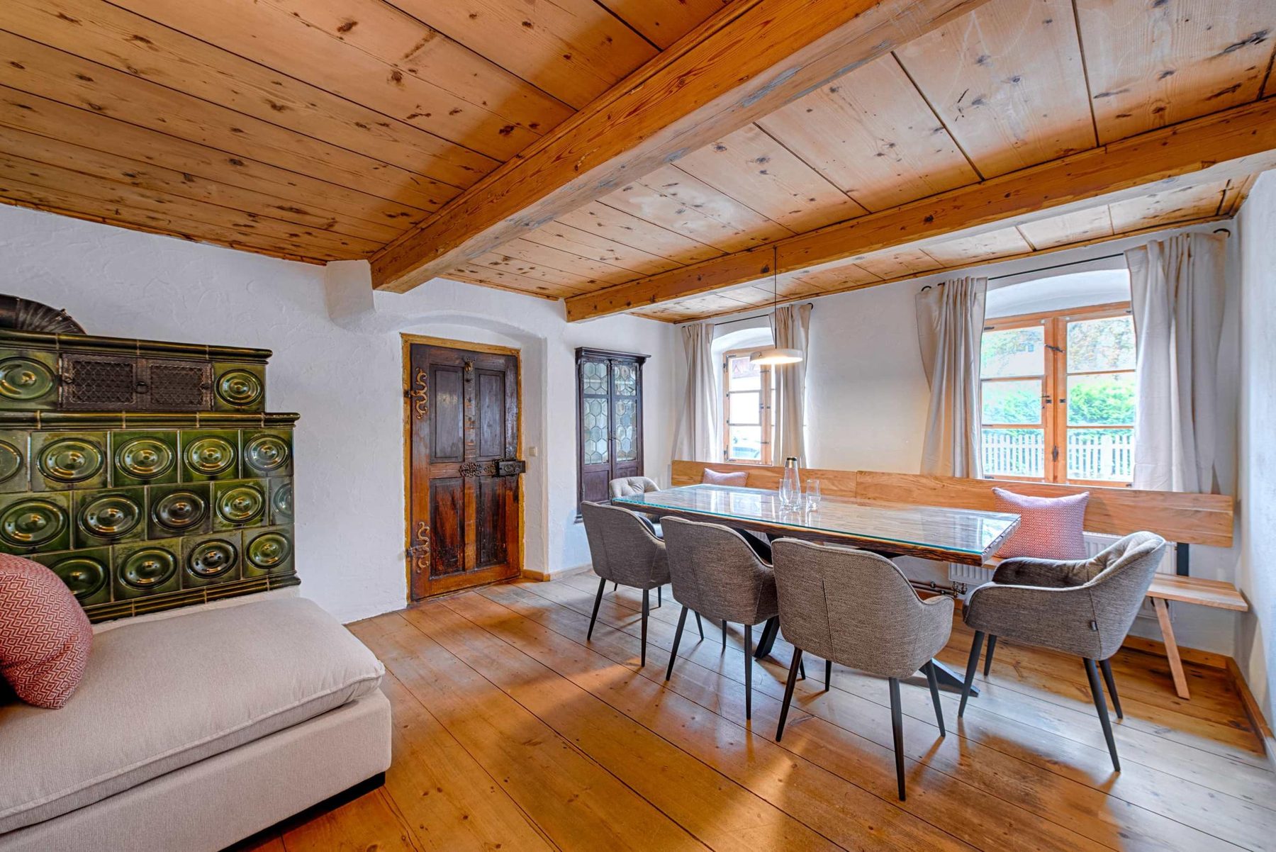 Dining room with the green tiled stove (Kachelofen) and a table for eight